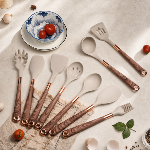 Silicone kitchen utensils with wooden handles arranged with tomatoes