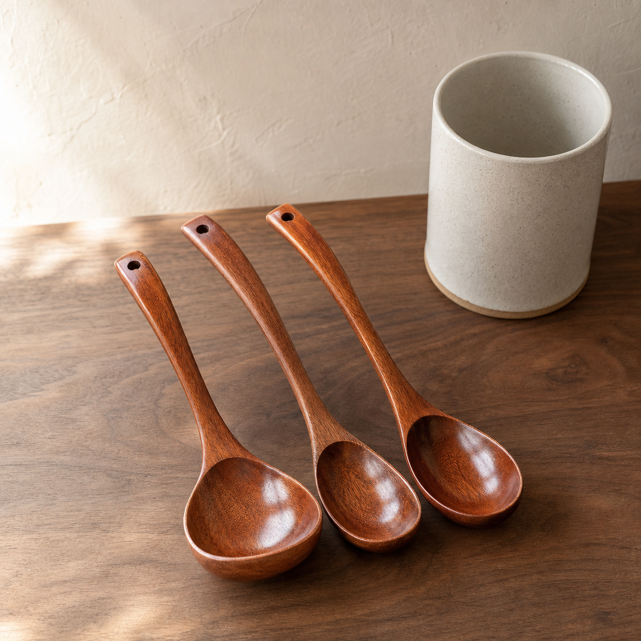 Long-handled bamboo soup spoon set organized on a walnut kitchen counter