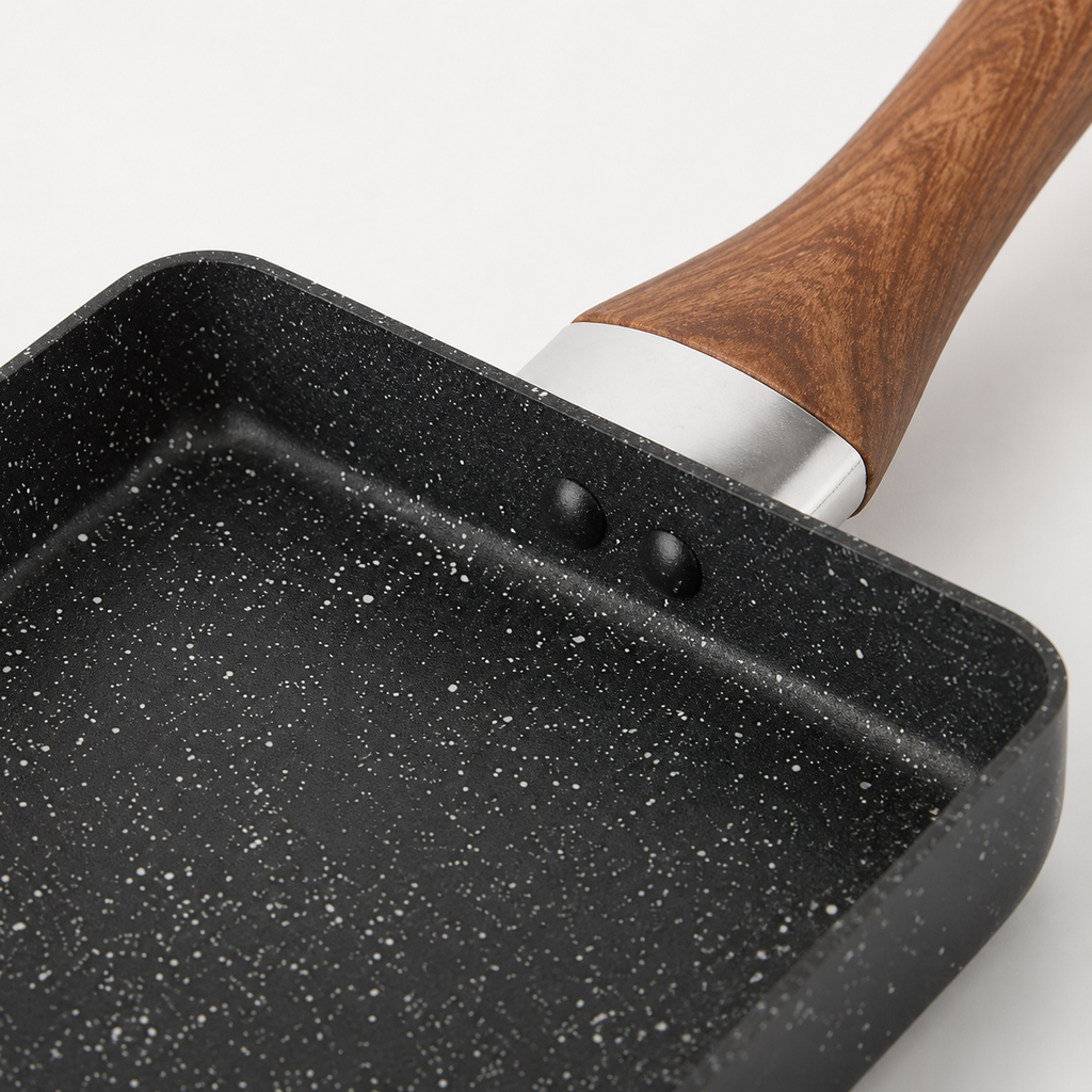Close-up of the pan coating, rivets and wood-grain handle